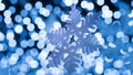 Big, glittering, and shimmering snowflake with beautiful blurry bokeh of blue, white tone lights in cold Christmas night.