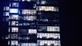 The glass facade of a modern skyscraper at night. Modern glass office in city. Royalty Free Stock Photo