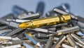 Big golden cross screwdriver bit on silvery bits heap of various sizes and types