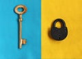 Big golden key on blue felt and close padlock on yellow felt