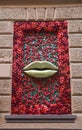 Big golden lips on the wall decorated roses