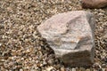 a big granite stone laying on the pebbles