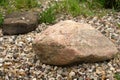 a big granite stone laying on the pebbles