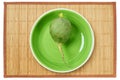Big green radish on a green plate on a cane tablecloth