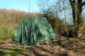 Big green tent on the ground surrounded by greens and trees in the forest Royalty Free Stock Photo