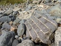 Big grey brick boulder block wall on a rocky beach waterfront