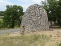 Big grey shelter made of rock on one side of road