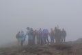 Big group of backpackers in the fog at the mountains Royalty Free Stock Photo