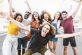 Big group of happy friends stands on city street with raised arms together - Multiracial young people having fun outdoor Royalty Free Stock Photo