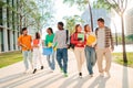 Big group of multiracial students walking together at university campus. Happy internacional teenagers laughing while Royalty Free Stock Photo