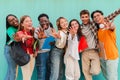 Big group of multiracial teenage students having fun and looking at camera at teal blue wall background. Happy young Royalty Free Stock Photo