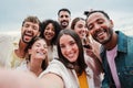 Big group of young adult happy friends smiling taking a selfie portrait and looking at camera with friendly expression Royalty Free Stock Photo