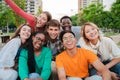 Big group of young adult real people smiling and having fun outdoors at vacations. Portrait of happy friends laughing Royalty Free Stock Photo