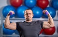 Big guy holding ridiculously small dumbbells Royalty Free Stock Photo