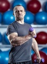 Big guy holding ridiculously small dumbbells Royalty Free Stock Photo