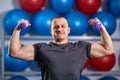 Big guy holding ridiculously small dumbbells Royalty Free Stock Photo