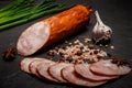 Big half of smoked ham sausage with sliced pieces, garlic and onion Royalty Free Stock Photo