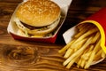 Big hamburger and french fries on wooden table Royalty Free Stock Photo