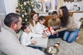 Big happy family with children gathering at home around New Years festive tree