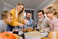 Big happy family with two kids eating Thanksgiving dinner. Roasted turkey on dining table. Parents and children having