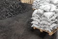 Big heap of dark black lump coal on floor bulk. Charcoal sorage at warehouse stock reserve. activated anthracite packed