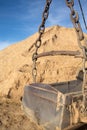 Big heavy bucket and mountain of sand close up