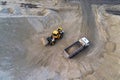 Big heavy wheel loader loading sand into dump truck in sand pit. Heavy industrial machinery concept Royalty Free Stock Photo