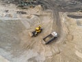 Big heavy wheel loader loading sand into dump truck in sand pit. Heavy industrial machinery concept Royalty Free Stock Photo