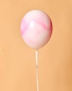 Big helium inflatable latex white balloon with pink spray paint decorations on birthday wedding corporative party on beige