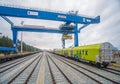 Big modern blue gantry crane and a railroad wagons