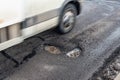 Big holes on asphalt road, passing blury car
