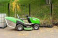 Big industrial lawnmower machine standing at parking in city park. Green lawn grass mower tractor at municipal street service area Royalty Free Stock Photo