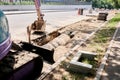 Big jackhammer drill drilling road.Heavy machinery crushing asphalt for stormwater drain repair. excavator tracks in the