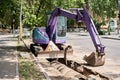 Big jackhammer drill drilling road.Heavy machinery crushing asphalt for stormwater drain repair. excavator tracks in the