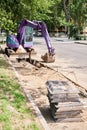 Big jackhammer drill drilling road.Heavy machinery crushing asphalt for stormwater drain repair. excavator tracks in the Royalty Free Stock Photo