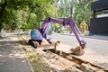 Big jackhammer drill drilling road.Heavy machinery crushing asphalt for stormwater drain repair. excavator tracks in the Royalty Free Stock Photo