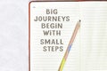 Big journeys begin with small steps on notebook with pencil isolated on gray background Royalty Free Stock Photo