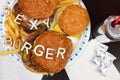 Big juicy burgers with fries on a paper plate with words SEXY BURGER on it