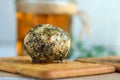 Big labne ball with herbs and spices on a background of a glass jar on a white table.