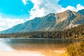 Big lake among autumn mountains and pines against the blue sky Royalty Free Stock Photo