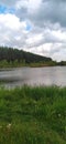 Big lake in Motizhen village, Kyiv region, Ukraine. beyond the lake is a forest with large green pines Royalty Free Stock Photo