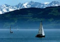 Big lake with sailboats and majestic mountains as background