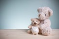 Big and little brown teddy bears with piggy banks on an old wooden table with copy space. Concept loan, banking, and save money. Royalty Free Stock Photo