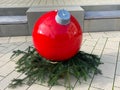 Christmas ball - x-mas ball - normally small little thing - in bright red with fir green on townhouse square in Ratingen, Germany Royalty Free Stock Photo