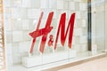 Big logo of Hennes and Mauritz or hm or H and M in showcase or shop window. Close-up