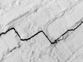 Big long tortuous crack on old plastering wall. Copy space. Black and white photo.