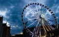 Big luminous ferris wheel in front of dark blue dramatic sky Royalty Free Stock Photo