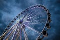Big luminous ferris wheel in front of dark blue dramatic sky Royalty Free Stock Photo