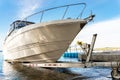 Big luxury cabin motorboat cruiser yacht launching at trailer ramp on river or lake. Warm morning sunrise sunshine Royalty Free Stock Photo