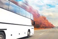 Big luxury comfortable tourist bus driving through golden autumn tree highway on bright sunny day. Blurred motion.Travel Royalty Free Stock Photo